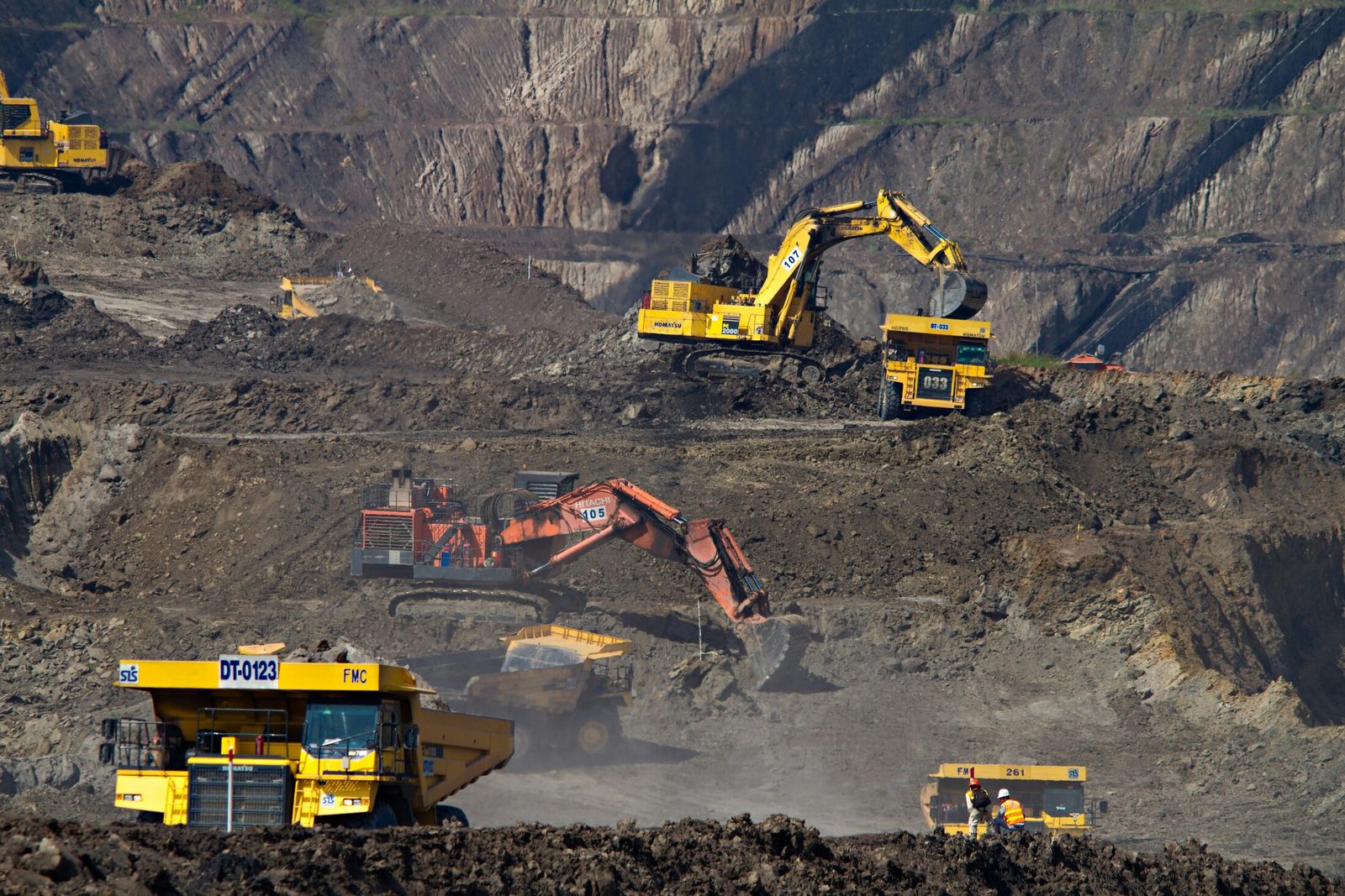 Fleet of haul trucks and excavators operating across an open-pit mine